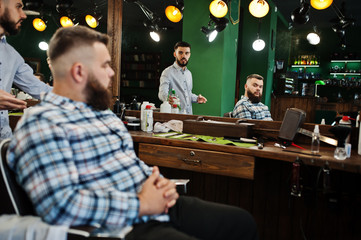 Handsome bearded man at the barbershop, barber at work.