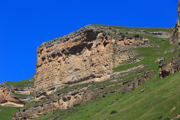 Stone ledge of a rocky ridge against the blue sky.