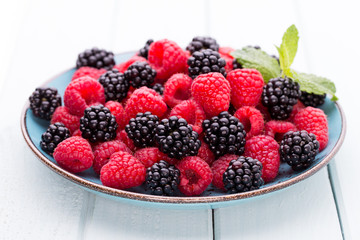 Fresh raspberries in a plate on a  vintage background.