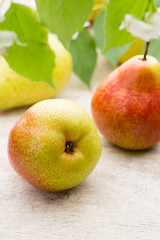 Fresh pears with leaves in a on wooden background.