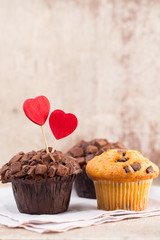 Homemade chocolate muffins with heart, vintage background.