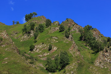 Fototapeta na wymiar Stone ledge of a rocky ridge against the blue sky. Caucasian mountain range in Russia.