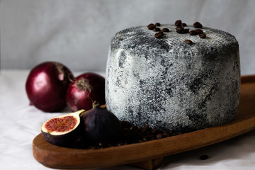 Cheese on a wooden table. Black cheese.