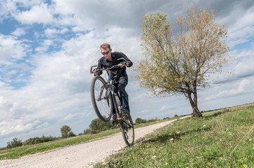 Fototapeta na wymiar Man riding a bicycle in nature blue sky