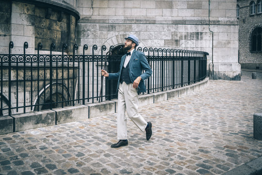 Homme style retro au chapeau et à la canne marchant dans les rue de Montmartre, Paris, France