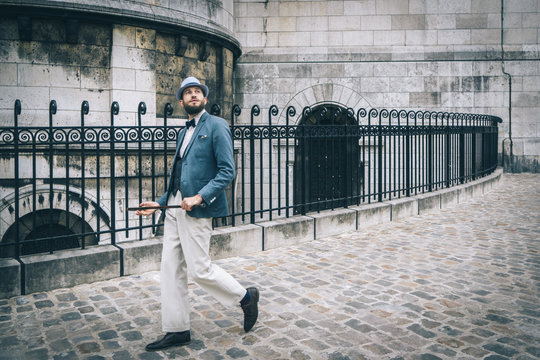 Homme style retro au chapeau et &agrave; la canne marchant dans les rue de Montmartre, Paris, France