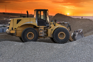 Excavator moving gravel in a rock processing plant for its transformation