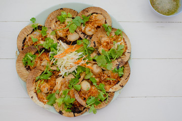 Oysters food and chili sauce, red onion fried Thai cuisine style on white wooden table background with copy space.