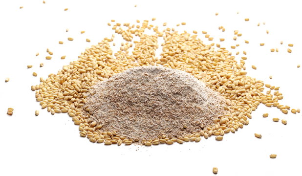 Integral wholewheat flour pile and wheat grains, kernels isolated on white background