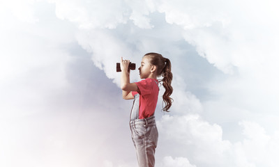 Concept of careless happy childhood with girl looking in binocul