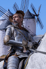 Don Quixote on horseback, with the windmills behind