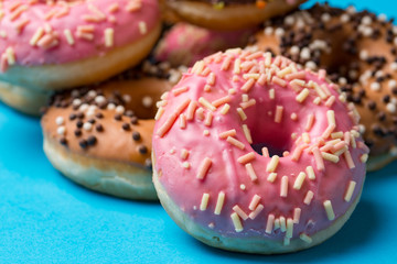 Colorful round donuts on blue background. Flat lay