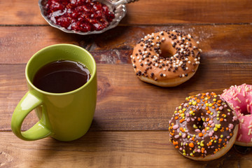 Coffee and donut. donut with a cup of tea on a dark wooden background.