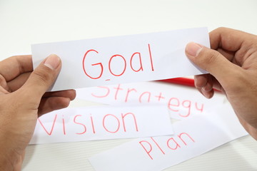 business hand holding a piece of goal paper