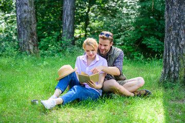Fototapeta premium Couple in love spend leisure reading book. Couple soulmates at romantic date. Romantic couple students enjoy leisure with poetry nature background. Pleasant weekend. Romantic date at green meadow