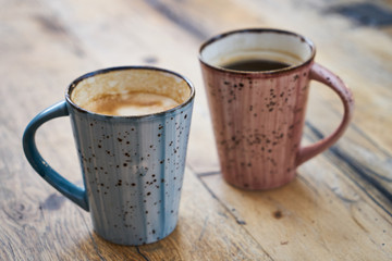 two coffee mugs on wooden table
