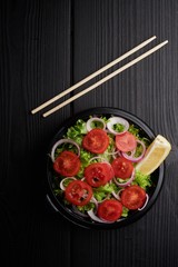 Tomato salad with lettuce, cheese and mustard and garlic dressing. Top view