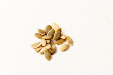 Peeled pumpkin seeds on white background