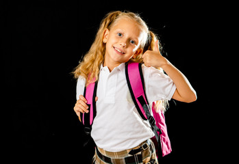 Funny cute primary student girl with backpack jumping and having fun