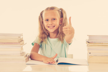 Cute smiling little girl with a pile of books feeling happy