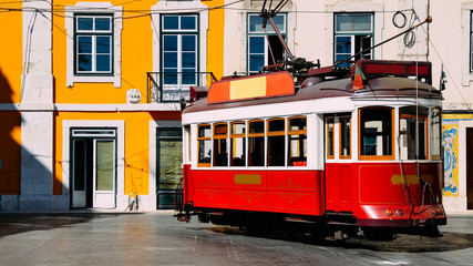 Naklejka na ściany i meble Vintage red and white tram on the street of Lisbon, Portugal
