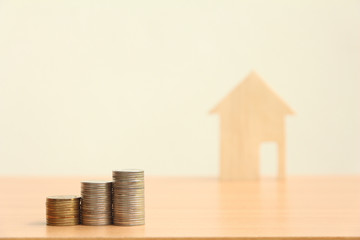 Coin stack with blurred wood house background,Saving money concept,new home in a housing development or community.