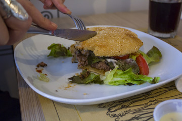 Eat a hamburger with fork and knife
