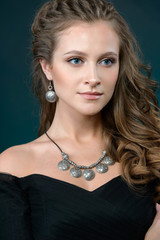 luxury jewelry and fashion concept. A model with earrings necklace and ring on dark background