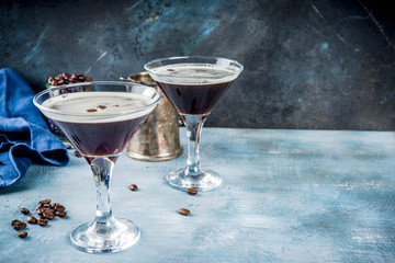 Coffee drink ideas, espresso martini cocktail, two glasses on blue concrete background copy space