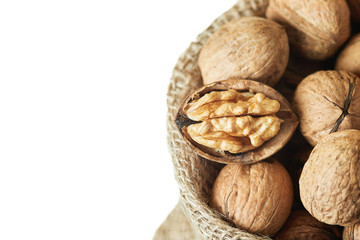 Whole walnuts (in shell) in burlap sack isolated on white background. Top view