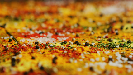 Closeup shot of various fresh spices spilled on surface of timber tabletop in kitchen