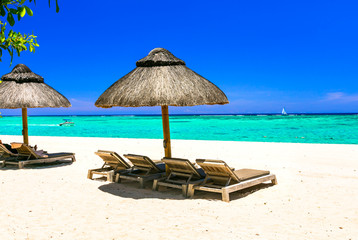 relaxing tropical holidays - beach chairs and umbrellas in white sandy beach of Mauritius island