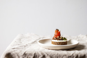 Danish smorrebrod sandwich with salmon and feta cheese on a wooden Board. Concept for restaurant and cafe.