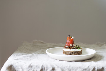 Danish smorrebrod sandwich with salmon and feta cheese on a wooden Board. Concept for restaurant and cafe.