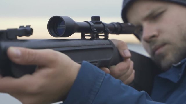 Close up of hunter aiming down his rifle in autumn season. the hunter shoots a rifle.