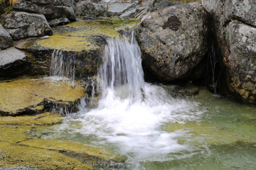 waterfall among stones in mountains