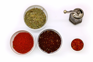 different spices in a white ceramic cup and mill for spices, isolated