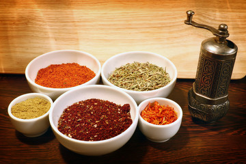 different spices in a white ceramic cup and mill for spices, isolated