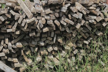 construction wood heap. badly pile wood on moisture dirt floor. wrong way of wood treatment.