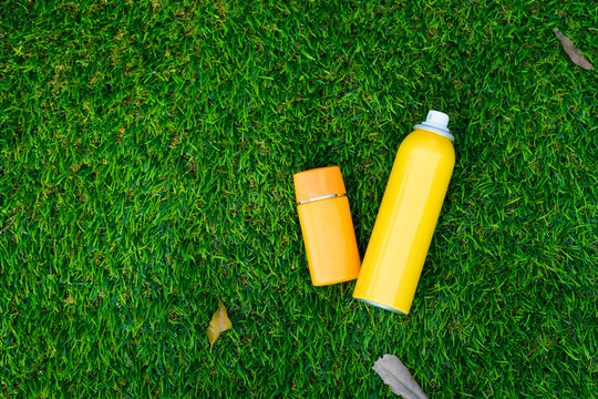 Sunscreen Body Spray And Sunscreen Facial Lotion On Green Grass