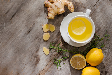 Cup of Ginger tea with lemon. Cup of Ginger tea with lemon. Glass mug of green hot tea on wooden table. Sliced lemons on a chopping board