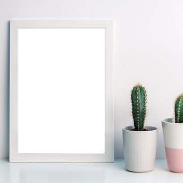 Panoramic photo of a white frame mockup with cactuses of a gray flowerpot with a pattern of sweater and one pastel pink terrazzo