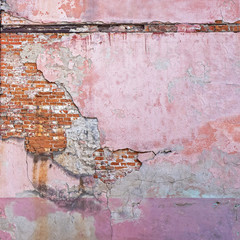 Abandoned grunge cracked red brick stucco wall