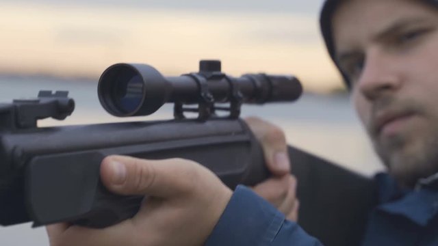 Close up of hunter aiming down his rifle in autumn season
