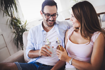 Happy attractive couple drinking together at home