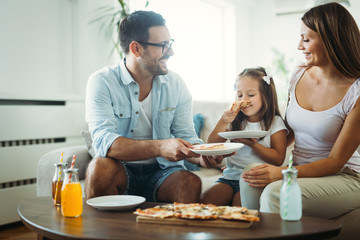 Portrait of happy family sharing pizza at home
