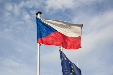 National flag of the Czech Republic and European union. Symbol of country, state, nation and EU are waving on the pole. Blue skywith cloud in the background