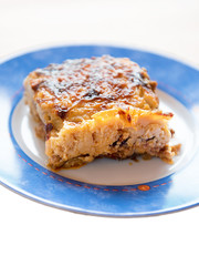 Moussaka or moussakas is an eggplant- (aubergine) or potato-based dish, often including ground meat, in the Levant, Middle East, and Balkans, with many local and regional variations