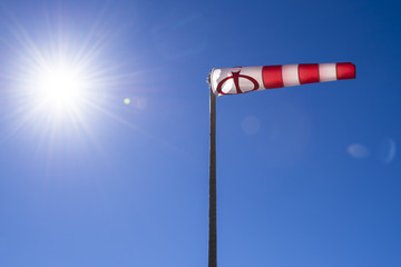 Ein Windsack und Sonne mit strahlend blauen Himmel