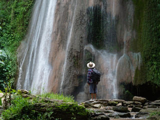 Senior man with backpacks enjoying looking at waterfall. Travel Lifestyle and success concept © xreflex